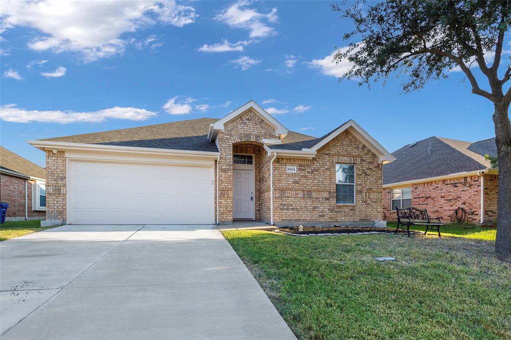 Single story home with a shingled roof, a garage, concrete driveway, a front yard, and brick siding