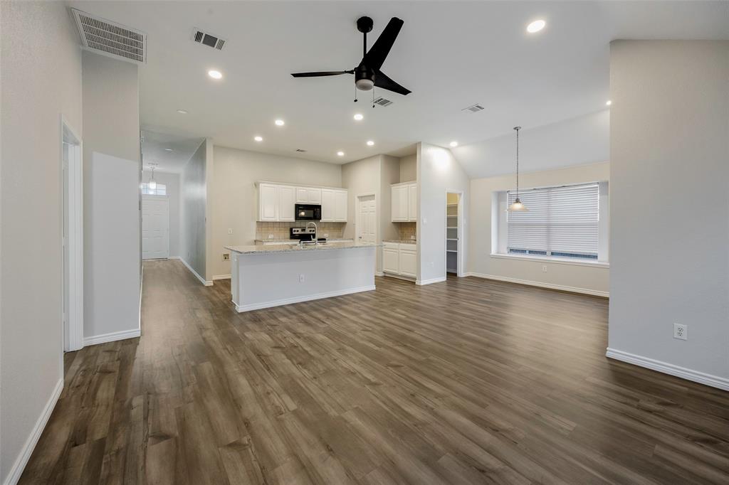 3603 Cottonwood Road Melissa, TX 75454 - Photo 2 of 22 Unfurnished living room with a ceiling fan, plenty of natural light, dark wood-type flooring, recessed lighting, and lofted ceiling