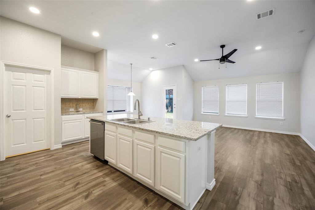 3603 Cottonwood Road Melissa, TX 75454 - Photo 3 of 22 Kitchen featuring decorative backsplash, white cabinetry, light stone counters, vaulted ceiling, and decorative light fixtures