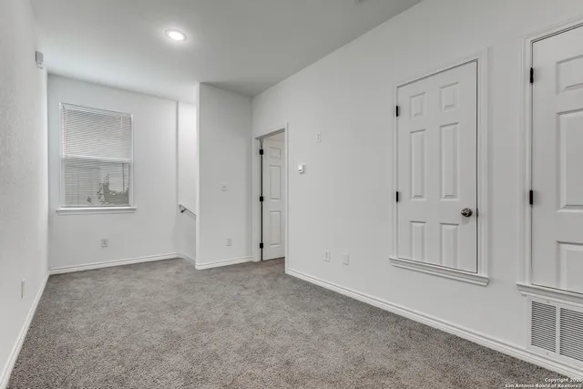 an empty room with windows and closet