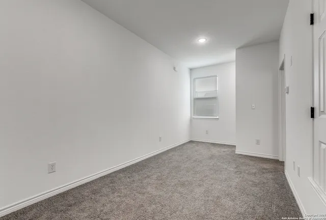 an empty room with closet and windows