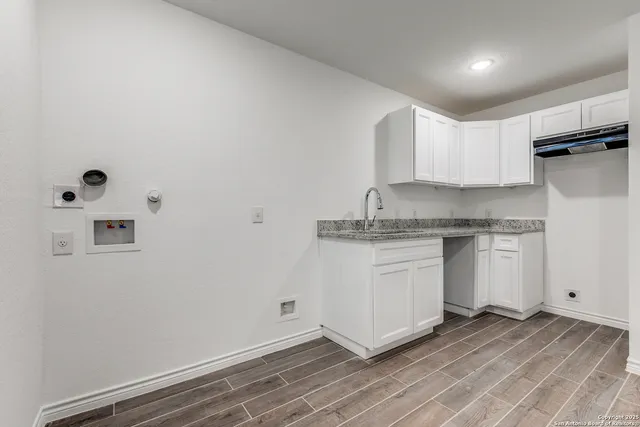 a kitchen with a refrigerator and white cabinets