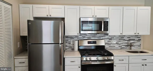 a kitchen with appliances a refrigerator and cabinets