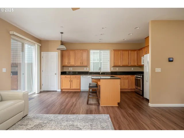 a kitchen with a refrigerator and a stove top oven