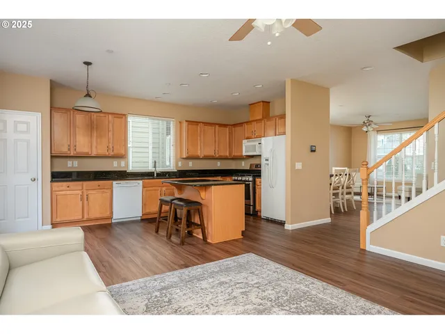 a kitchen with granite countertop a refrigerator and a stove top oven