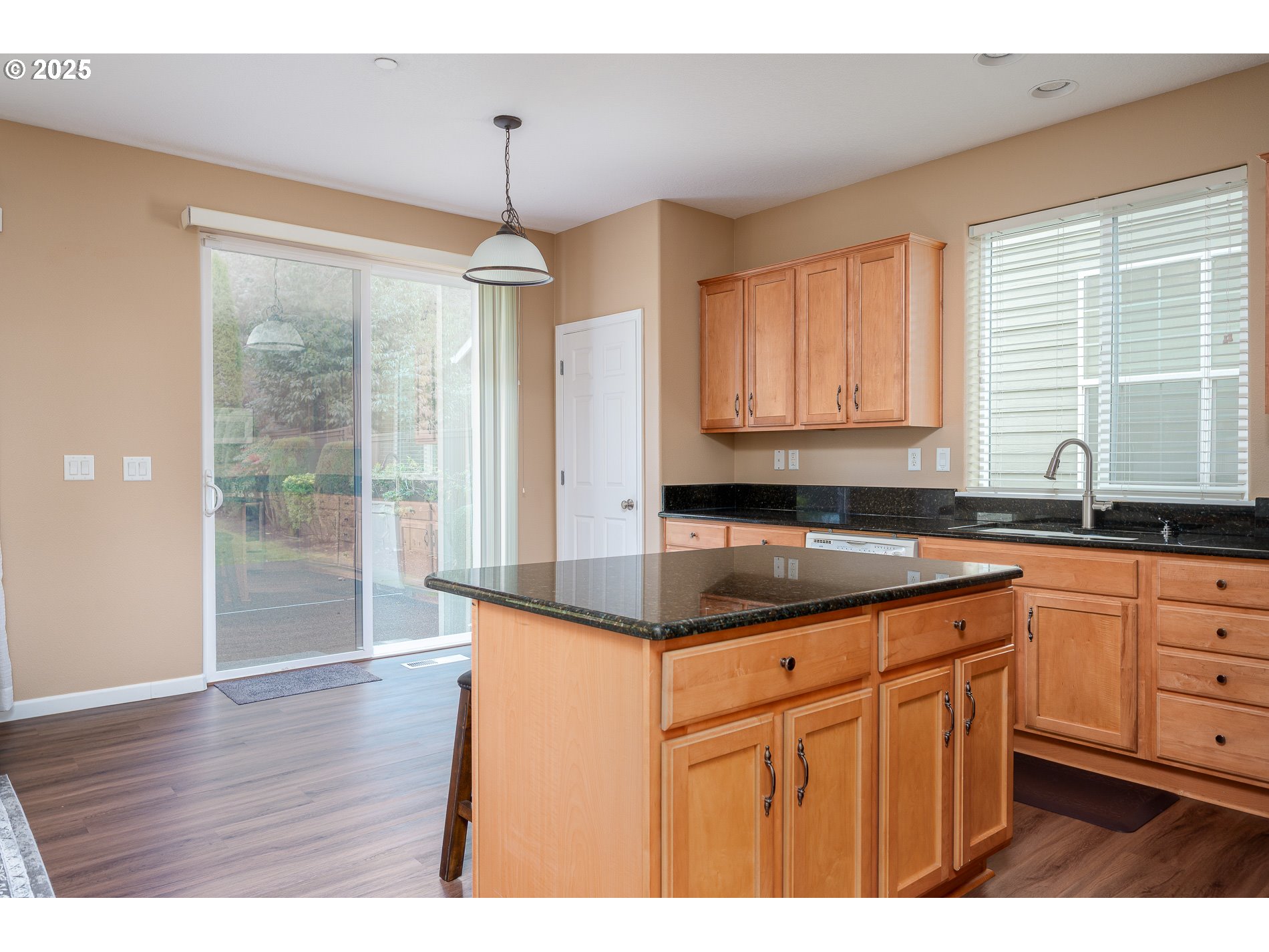 10636 Southwest 43rd Avenue Portland, OR 97219 - Photo 17 of 48 a kitchen with kitchen island granite countertop a sink cabinets and wooden floor