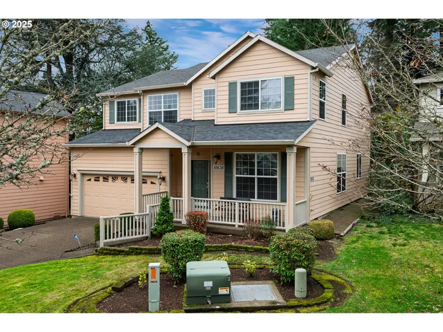 a front view of a house with a yard and potted plants