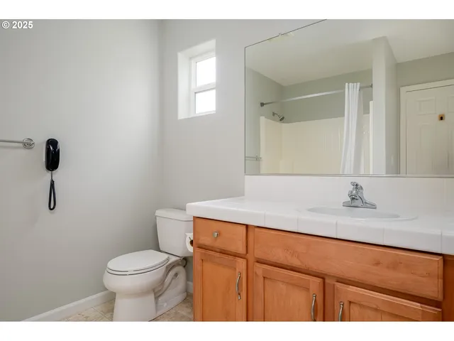 a bathroom with a granite countertop toilet sink and mirror