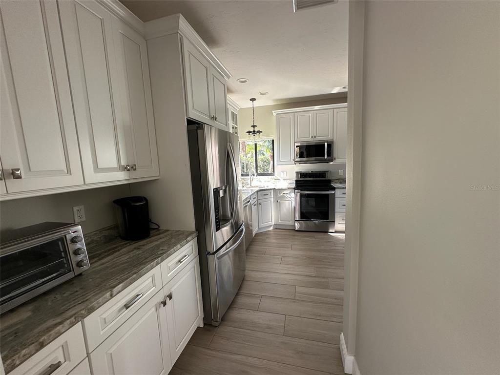 195 Inlets Boulevard, Unit 195 Nokomis, FL 34275 - Photo 11 of 48 a kitchen with stainless steel appliances a refrigerator and a stove top oven