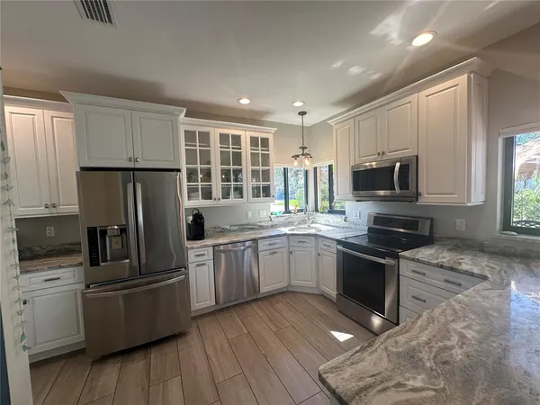 a kitchen with stainless steel appliances a stove a sink and a microwave