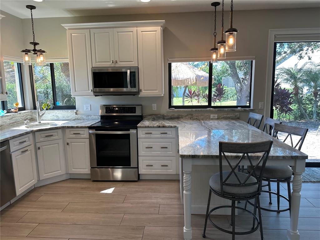 195 Inlets Boulevard, Unit 195 Nokomis, FL 34275 - Photo 13 of 48 a kitchen with stainless steel appliances a stove a sink and a microwave