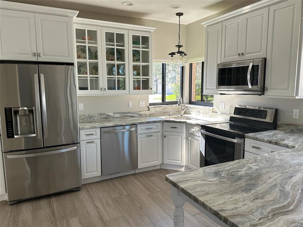 195 Inlets Boulevard, Unit 195 Nokomis, FL 34275 - Photo 14 of 48 a kitchen with stainless steel appliances granite countertop a stove a sink dishwasher a refrigerator microwave and sink
