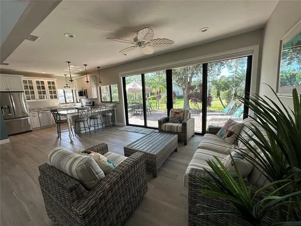 a dining room with furniture a chandelier and wooden floor