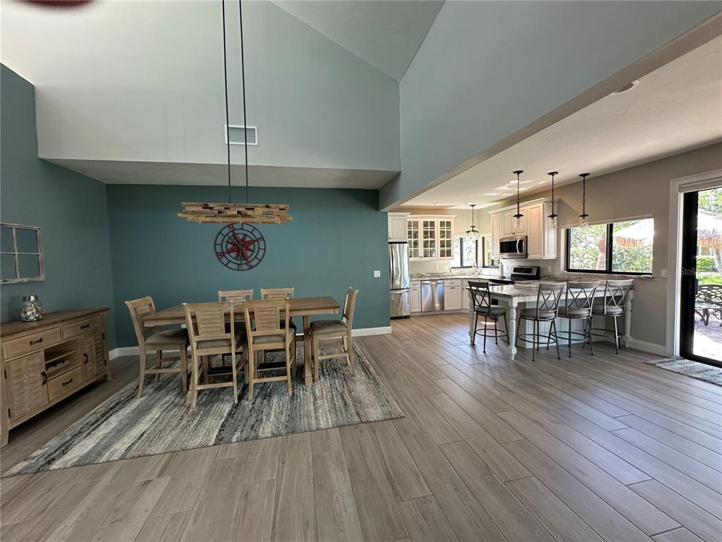 195 Inlets Boulevard, Unit 195 Nokomis, FL 34275 - Photo 18 of 48 a dining room with furniture a chandelier and wooden floor