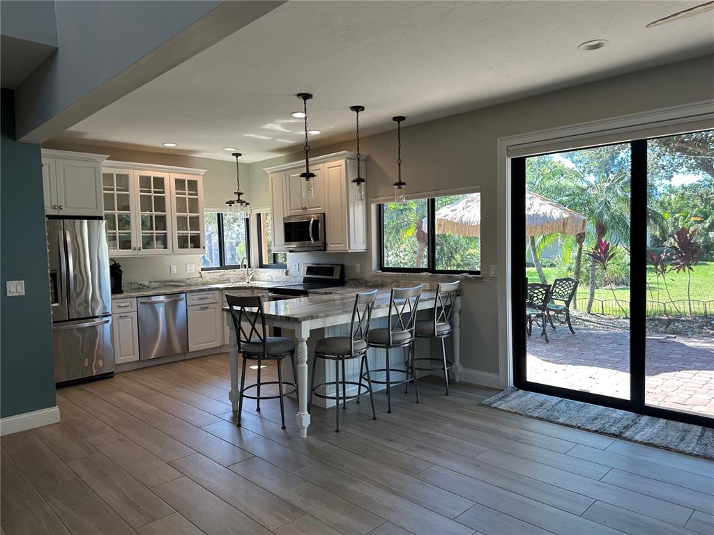 195 Inlets Boulevard, Unit 195 Nokomis, FL 34275 - Photo 21 of 48 a view of a dining room with furniture and wooden floor