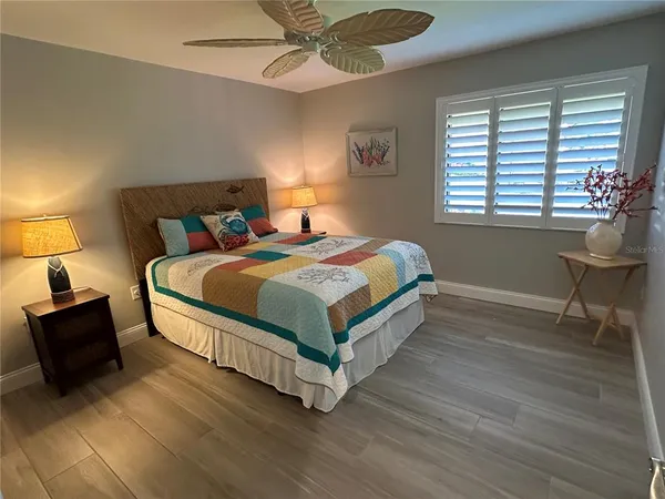 a bedroom with a bed and a lamp on the dresser
