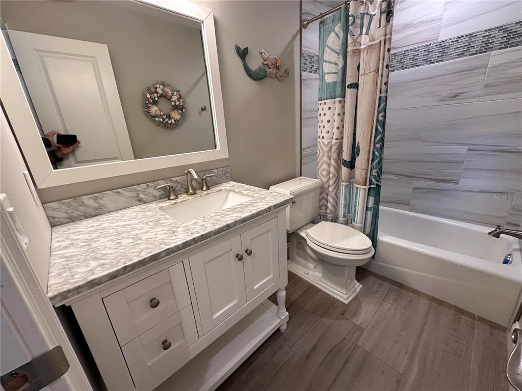 195 Inlets Boulevard, Unit 195 Nokomis, FL 34275 - Photo 36 of 48 a bathroom with a granite countertop sink toilet and shower