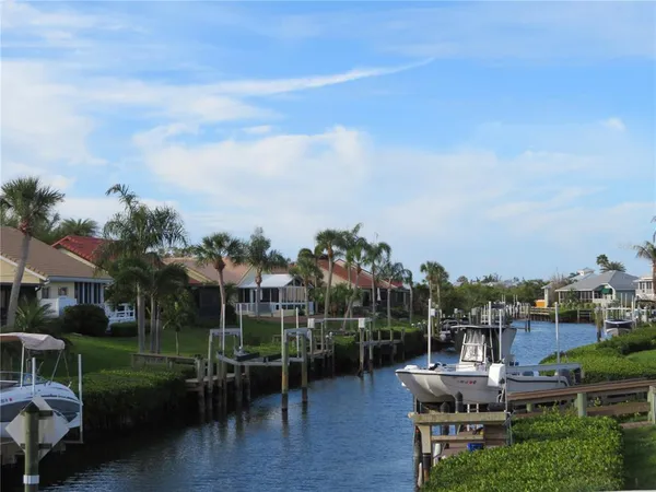a sign board with a yard and palm trees