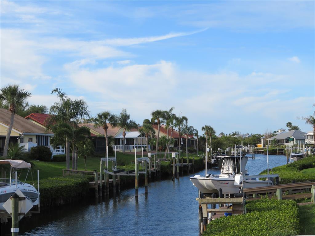 195 Inlets Boulevard, Unit 195 Nokomis, FL 34275 - Photo 40 of 48 a view of a chairs and table in patio with a yard