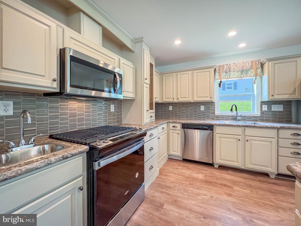 146 Minch Road Parkesburg, PA 19365 - Photo 12 of 44 a kitchen with stainless steel appliances granite countertop wooden cabinets stove top oven and sink