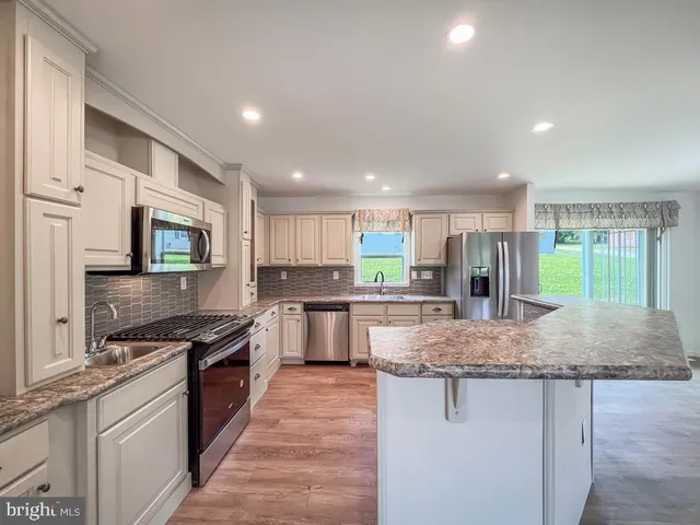 a kitchen with stainless steel appliances granite countertop a stove top oven a sink and dishwasher