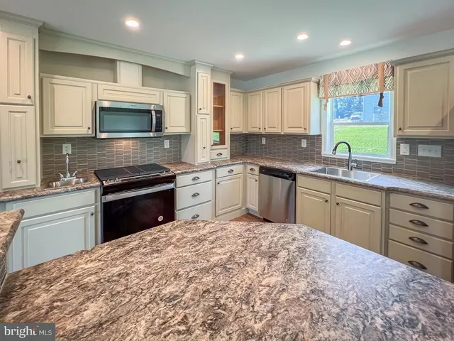 a kitchen with a sink stove and microwave