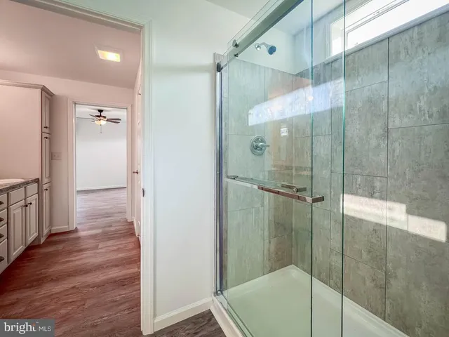 a bathroom with a granite countertop sink a mirror and a shower