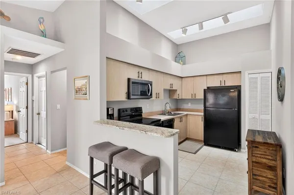 a kitchen with stainless steel appliances granite countertop a refrigerator and a stove top oven