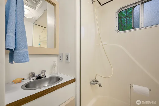 a bathroom with a sink and mirror with window