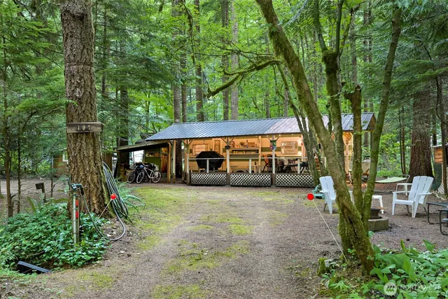 a view of a house with large tree and next to a yard