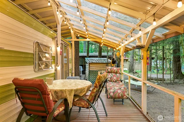 a view of a patio with table and chairs a barbeque with wooden floor and fence
