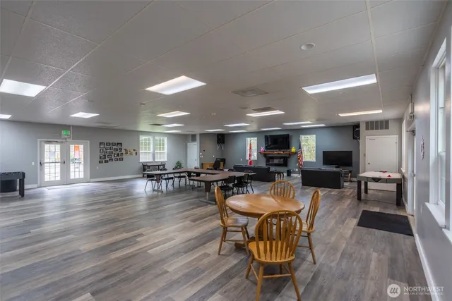 a large dining space with furniture a rug and wooden floor