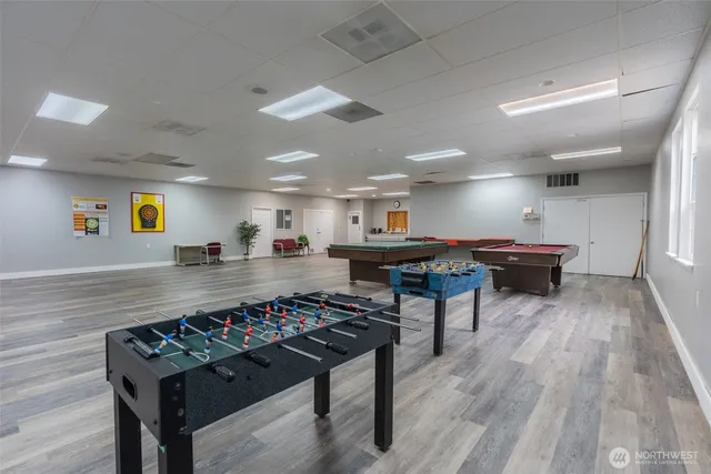 a room with pool table and a wooden floor