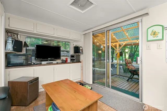 a living room with furniture a flat screen tv and a floor to ceiling window