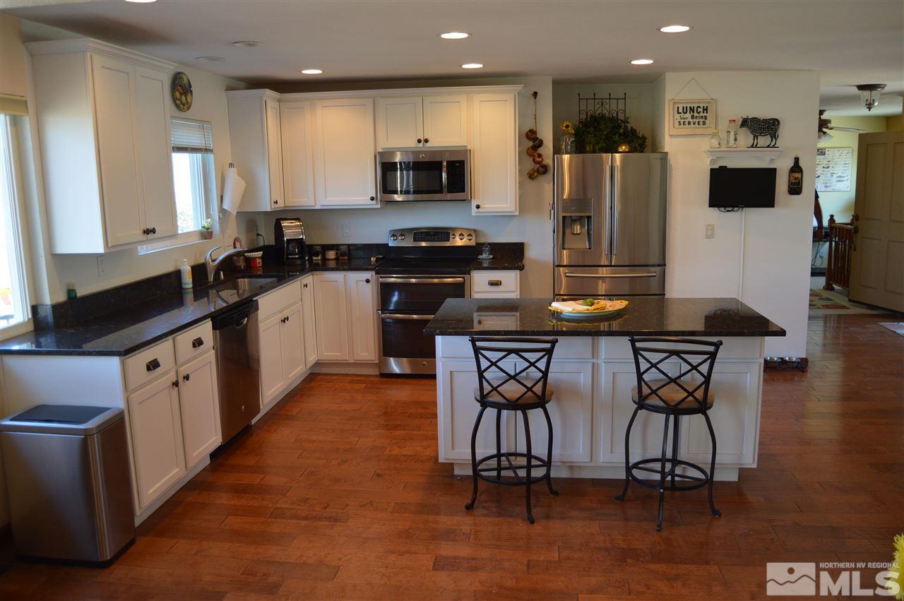 5860 Quaking Aspen Road Reno, NV 89510 - Photo 7 of 25 a kitchen with stainless steel appliances granite countertop a stove top oven a sink a refrigerator and a microwave