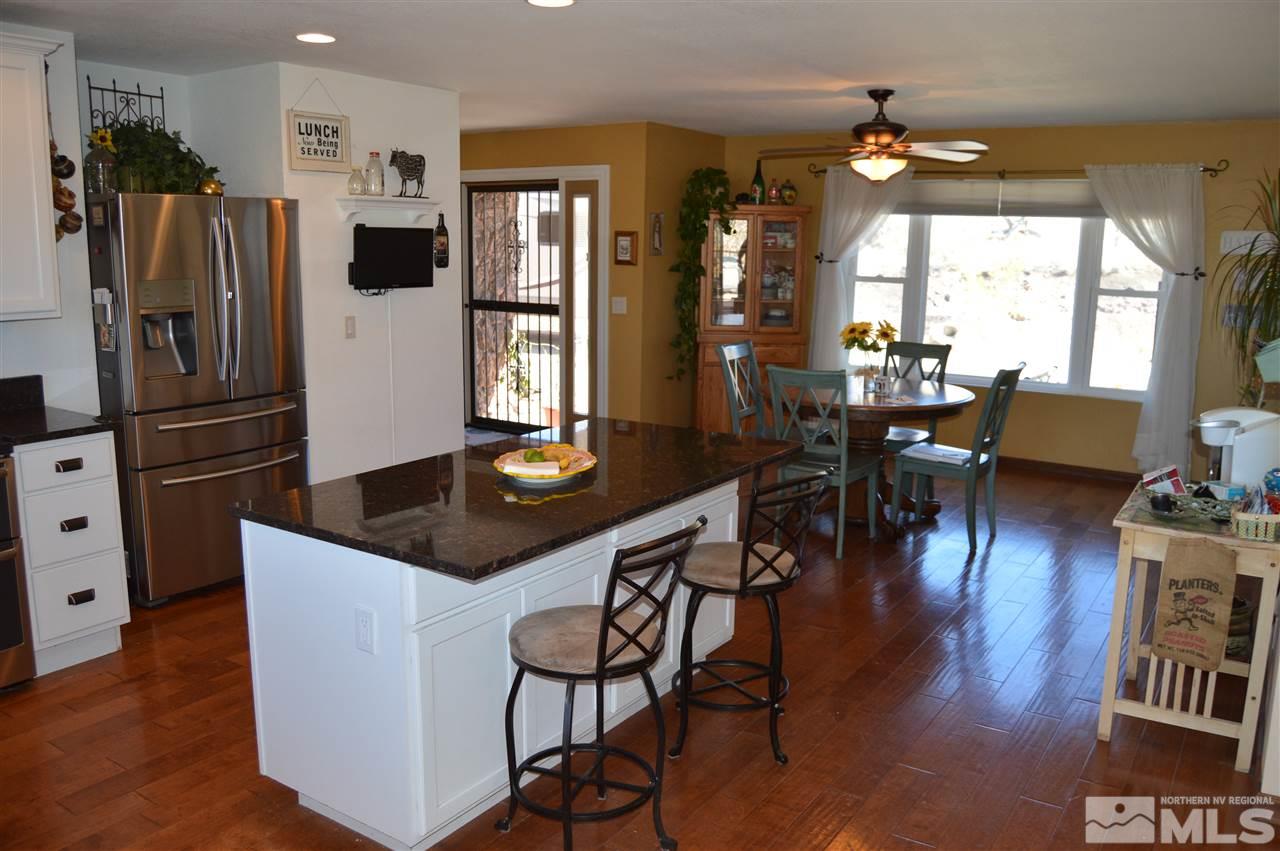 5860 Quaking Aspen Road Reno, NV 89510 - Photo 8 of 25 a kitchen with stainless steel appliances granite countertop a table chairs and a refrigerator