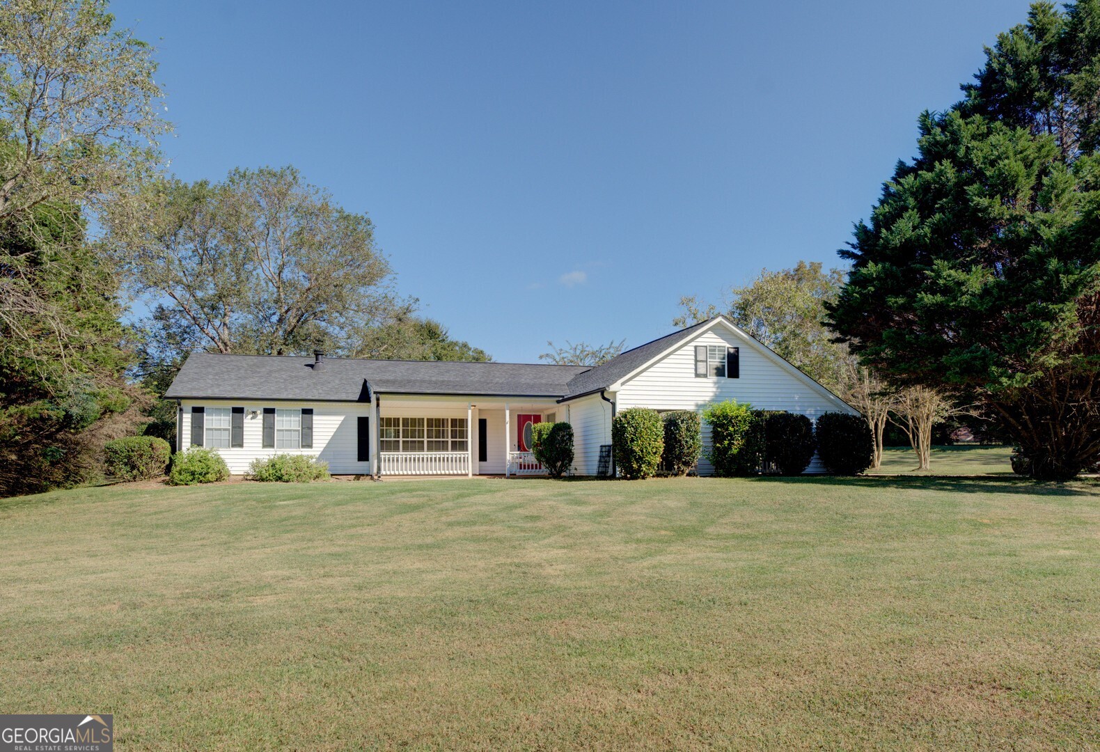 a front view of residential houses with yard and trees