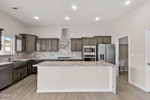 a large kitchen with stainless steel appliances and a sink