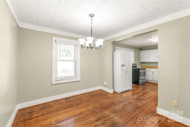 a view of a room with wooden floor staircase and a kitchen
