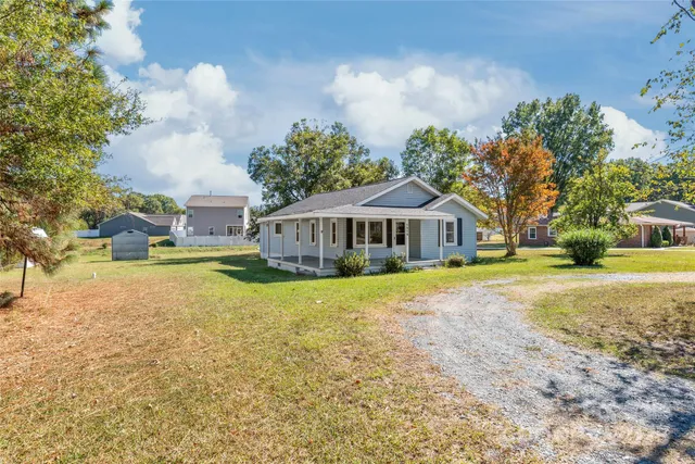 a view of a house with yard and sitting area