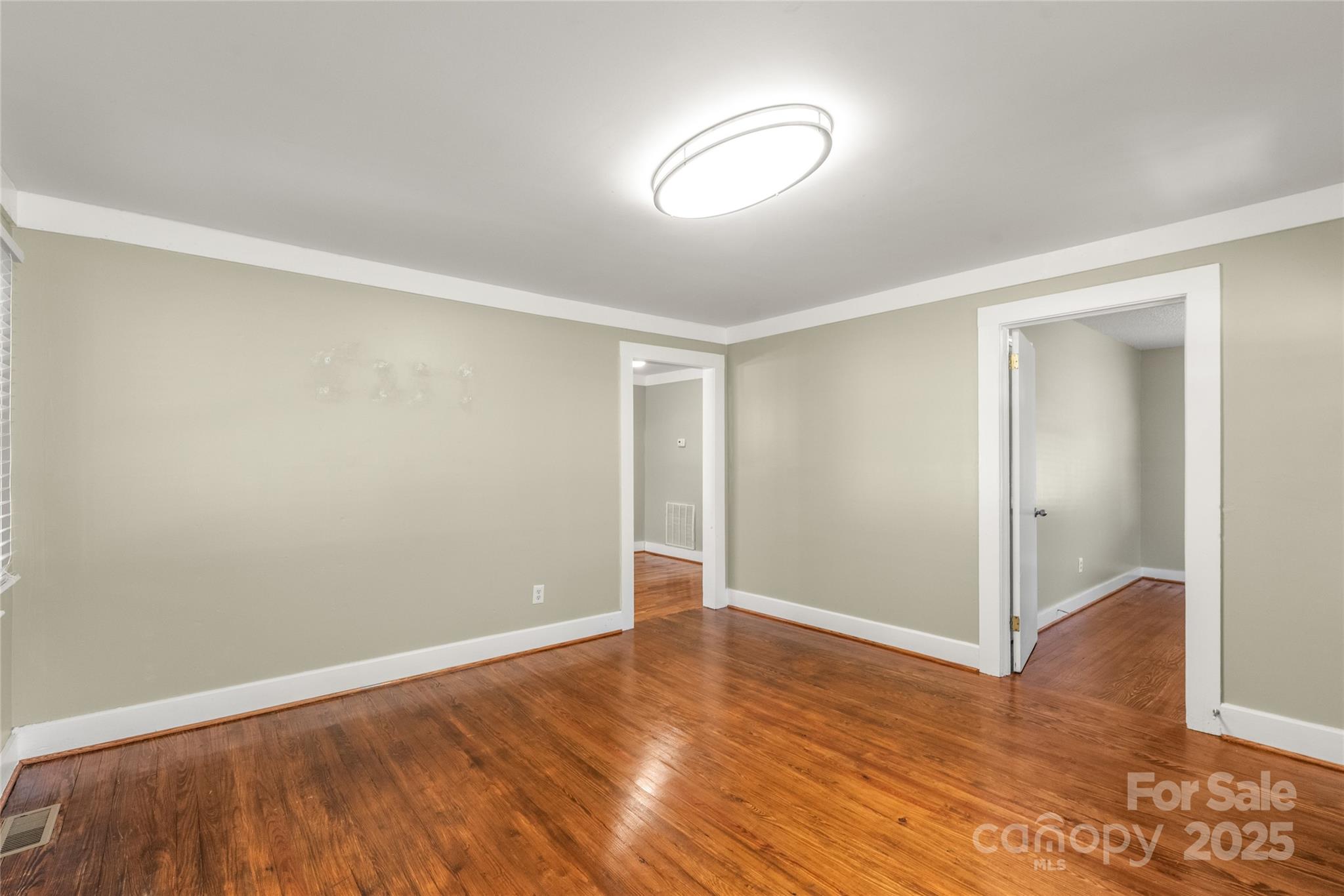 1914 John Moore Road Monroe, NC 28110 - Photo 7 of 27 an empty room with wooden floor and windows