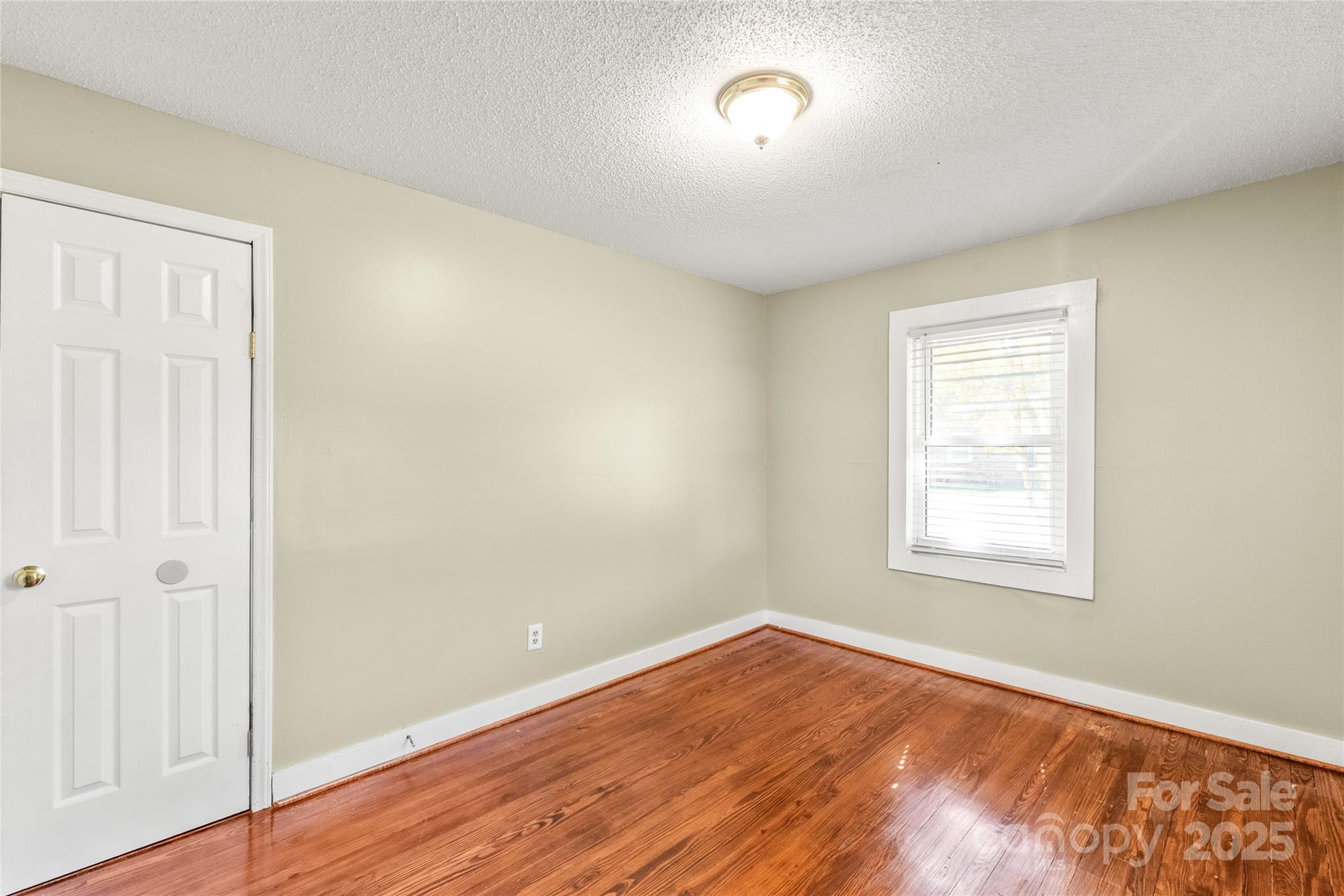 1914 John Moore Road Monroe, NC 28110 - Photo 9 of 27 an empty room with wooden floor and windows