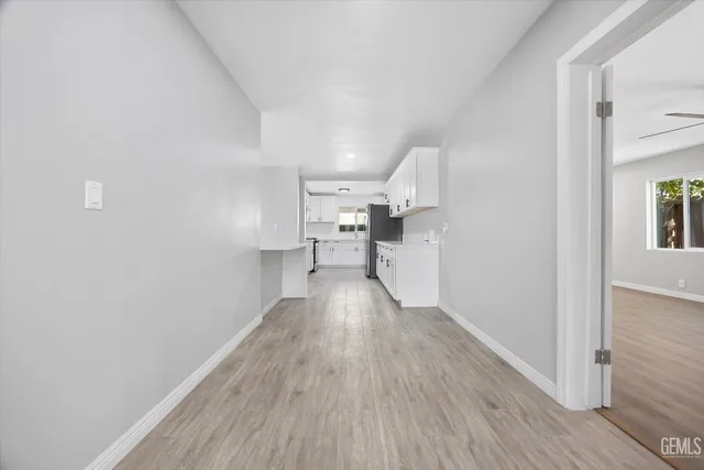 a kitchen with stainless steel appliances a refrigerator and a wooden floor