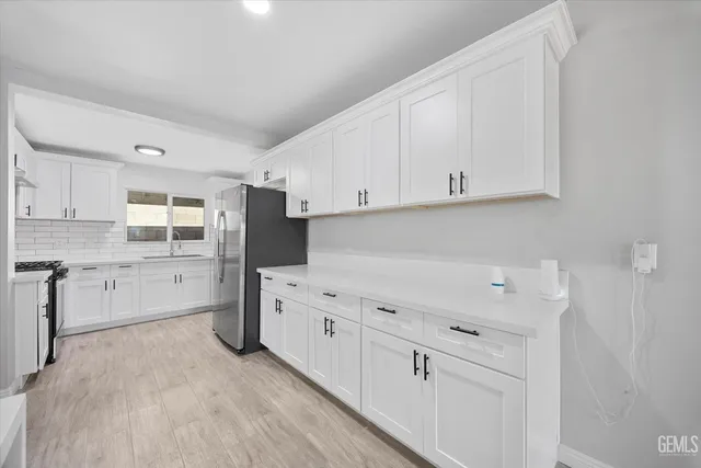 a kitchen with stainless steel appliances a refrigerator sink and cabinets