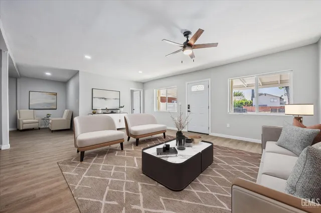 a living room with furniture a window and wooden floor