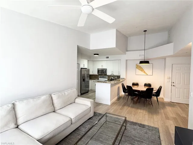 a living room with furniture and kitchen view