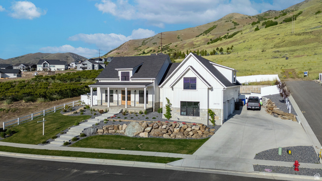 2013 South 100 West Perry, UT 84302 - Photo 39 of 49 Modern farmhouse-style residence featuring white vertical siding, a dark shingle roof, and stone accents