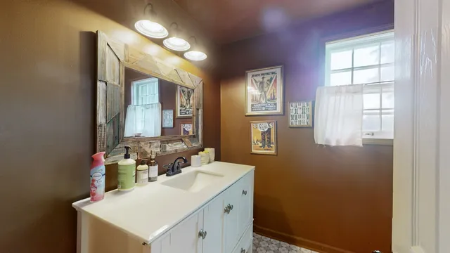 a bathroom with a sink vanity and a mirror