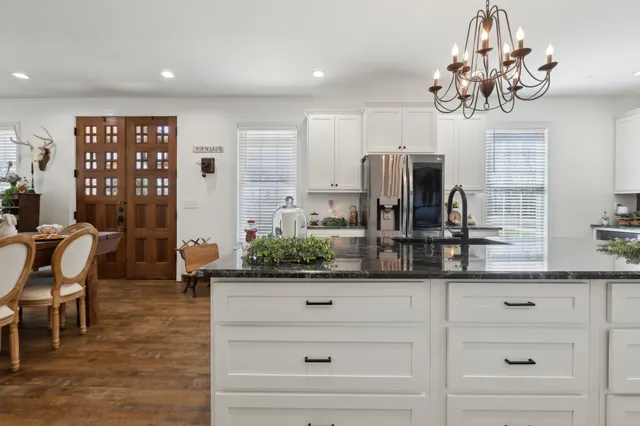a kitchen with stainless steel appliances kitchen island granite countertop a table and chairs in it