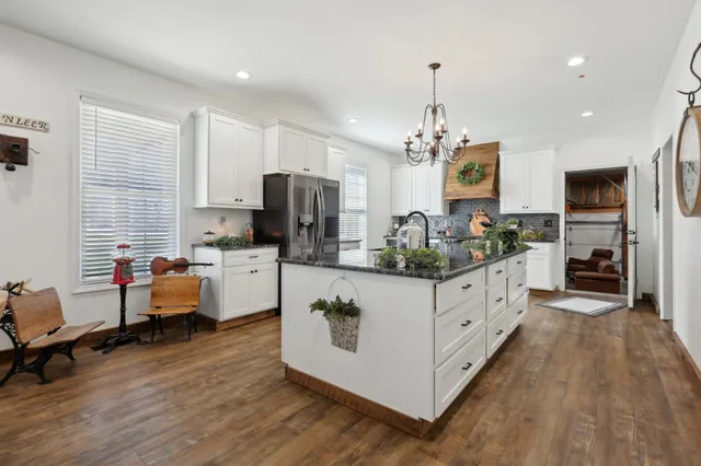 a kitchen with kitchen island granite countertop a stove oven and a refrigerator with cabinets